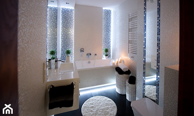 mała nowoczesna łazienka, czarne płytki podłogowe, okrągły biały dywan, lustro ścienne z szarą ramą
