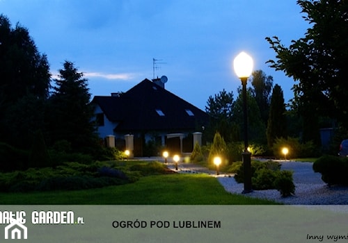 Ogród pod Lublinem - Duży z nawierzchnią pokrytą kostką brukową z lampami stojącymi ogród przed domem - zdjęcie od Lunatic Garden
