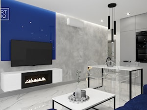 Salon w szarości i bieli z biokominkiem i granatowym lacobelem za telewizorem - zdjęcie od Miliart Studio
