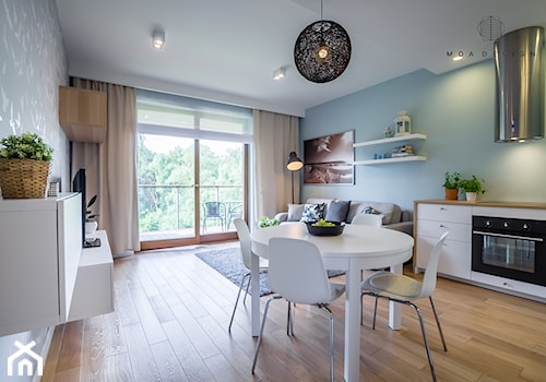 Realizacja nadmorskiego apartamentu - Średni niebieski turkusowy salon z kuchnią z jadalnią z tarasem / balkonem, styl skandynawski - zdjęcie od MOA design