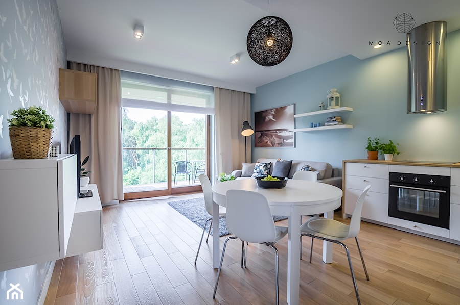 Realizacja nadmorskiego apartamentu - Średni niebieski turkusowy salon z kuchnią z jadalnią z tarasem / balkonem, styl skandynawski - zdjęcie od MOA design