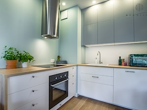 Realizacja nadmorskiego apartamentu - Średnia otwarta z salonem biała z zabudowaną lodówką z nablatowym zlewozmywakiem kuchnia w kształcie litery l, styl skandynawski - zdjęcie od MOA design