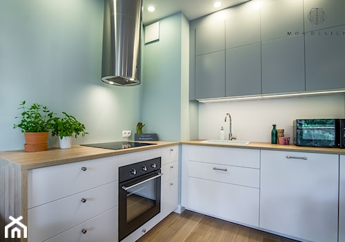 Realizacja nadmorskiego apartamentu - Średnia otwarta z salonem biała z zabudowaną lodówką z nablatowym zlewozmywakiem kuchnia w kształcie litery l, styl skandynawski - zdjęcie od MOA design