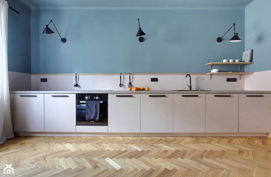Klimatyczne mieszkanie na Pradze - Duża otwarta z salonem z kamiennym blatem biała niebieska z zabudowaną lodówką z nablatowym zlewozmywakiem kuchnia jednorzędowa z oknem z kompozytem na ścianie nad blatem kuchennym, styl minimalistyczny - zdjęcie od Piotr Motrenko