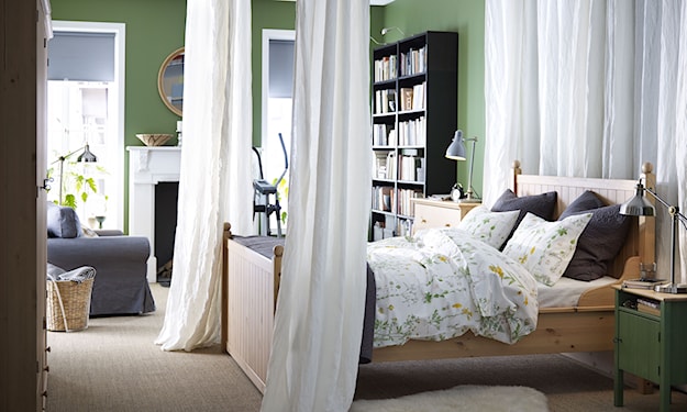sypialnia z zielonymi ścianami i baldachim