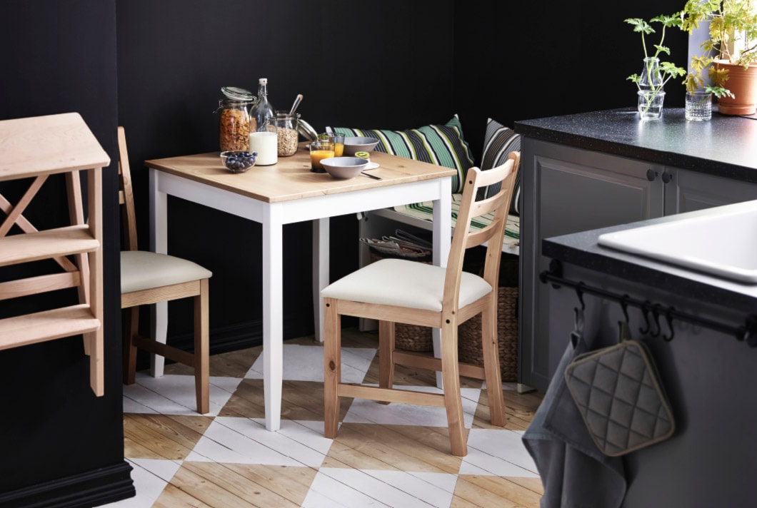 czarne ściany w jadalni, podłoga z jasnego drewna, szare szafki kuchenne, stół z jasnego drewna