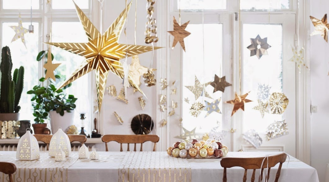 złote gwiazdki wiszące nad stołem, drewniane krzesło, biały obrus, bieżniki ze złotym wzorem