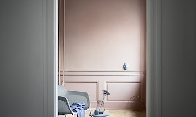 salon z szarym fotelem i różowymi ścianami 