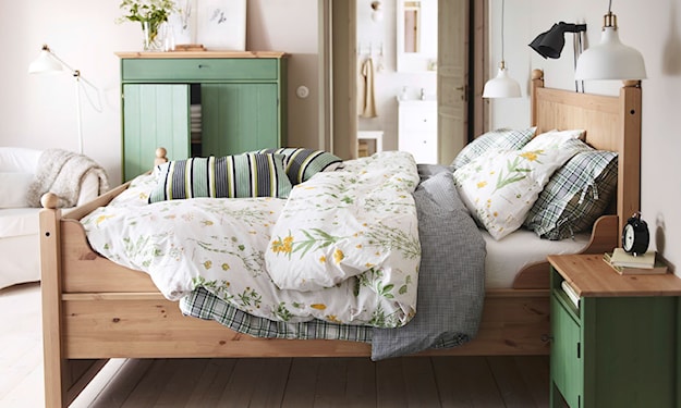 zielona szafka nocna, drewniana rama łóżka, biała pościel w kwiaty, biała lampa wisząca