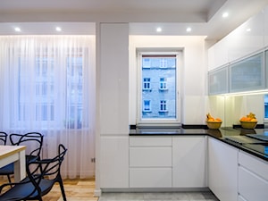 7 - Mała otwarta z salonem z kamiennym blatem biała z zabudowaną lodówką kuchnia w kształcie litery l z oknem, styl nowoczesny - zdjęcie od Meble Wiśniewski MEBLO-MARK