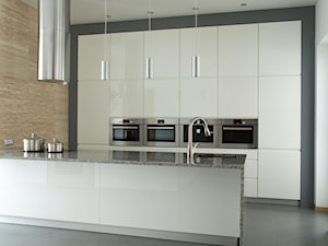 Projekty i realizacje kuchni - Średnia otwarta z kamiennym blatem biała z zabudowaną lodówką z podblatowym zlewozmywakiem kuchnia dwurzędowa, styl minimalistyczny - zdjęcie od Meblostyl
