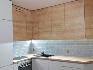 Kuchnia - Mała otwarta biała z zabudowaną lodówką z nablatowym zlewozmywakiem kuchnia w kształcie litery l, styl nowoczesny - zdjęcie od Promeb