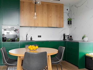 Zielone fronty kuchenne połączone z naturalnym fornirem dębowym oraz matowymi płytkami imitującymi marmur - zdjęcie od URZĄDZARNIA Marta Lebiedzińska