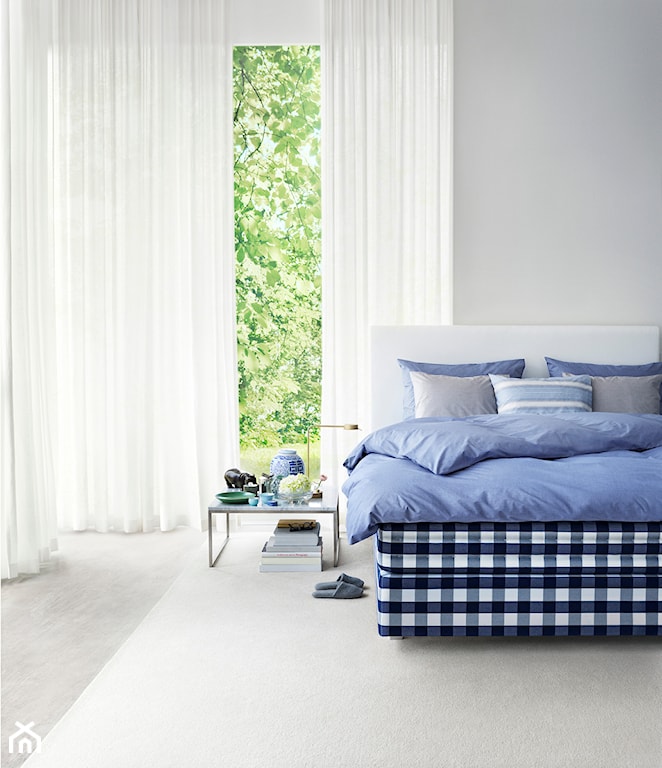 biało-granatowe łóżko, białe zasłony, niebieska pościel, biały dywan