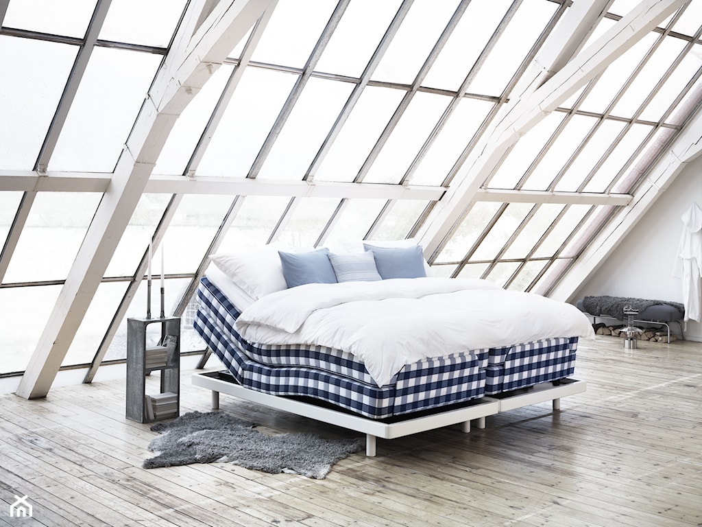 loft, drewniana podłoga, łóżko w biało-granatową kratę, szary dywan