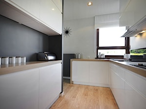 Apartament Altoria - Średnia biała z zabudowaną lodówką kuchnia dwurzędowa z kompozytem na ścianie nad blatem kuchennym - zdjęcie od Pracownia Wnętrza - przestrzeń szyta na miarę