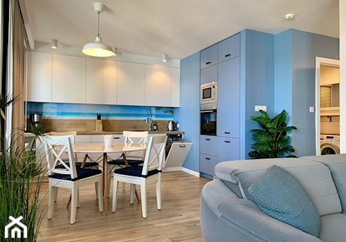 MIESZKANIE MIĘDZYZDROJE - Średnia otwarta z salonem biała niebieska z zabudowaną lodówką kuchnia w kształcie litery l z oknem, styl skandynawski - zdjęcie od KADA WNĘTRZA S.C