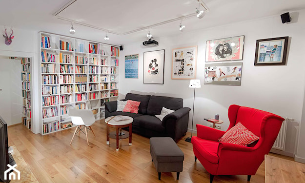 czerwony fotel, grafitowa sofa, drewniana podłoga, biały fotel, regał z ksiązkami