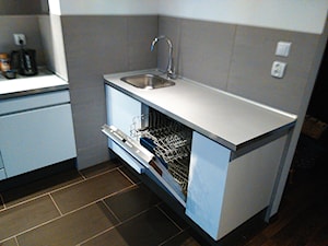 Montaż kuchni - Mała otwarta z kamiennym blatem szara z zabudowaną lodówką z nablatowym zlewozmywakiem kuchnia jednorzędowa - zdjęcie od GotekService