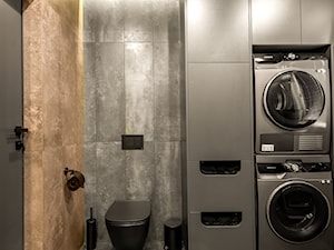 Ciemna łazienka z funkcjonalną zabudową meblową pod pralkę i suszarkę. - zdjęcie od Viva Design Rzeszów