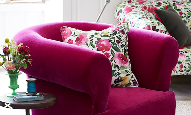 różowy fotel, poduszka w kwiaty, okrągły stolik
