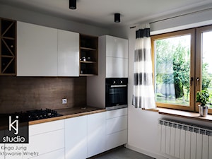 Kuchnia 12m2 - realizacja - Biała brązowa z zabudowaną lodówką kuchnia z oknem, styl nowoczesny - zdjęcie od KJ Studio Projektowanie wnętrz