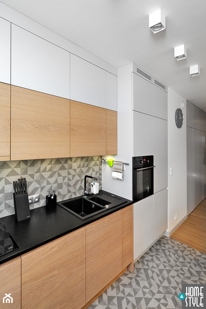 REALIZACJA mieszkania z czarnym jeleniem - Mała otwarta z salonem biała z zabudowaną lodówką z podblatowym zlewozmywakiem kuchnia jednorzędowa, styl nowoczesny - zdjęcie od HOME & STYLE Katarzyna Rohde