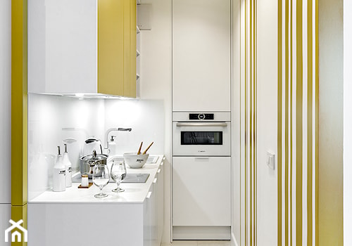 REALIZACJA apartamentu hotelowego - Mała z żółtymi frontami zamknięta z salonem biała żółta z zabudowaną lodówką z nablatowym zlewozmywakiem kuchnia jednorzędowa, styl nowoczesny - zdjęcie od HOME & STYLE Katarzyna Rohde