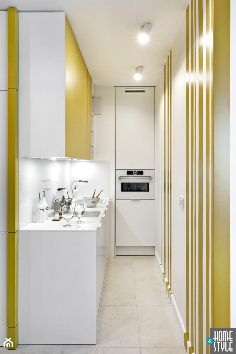 REALIZACJA apartamentu hotelowego - Mała z żółtymi frontami zamknięta z salonem biała żółta z zabudowaną lodówką z nablatowym zlewozmywakiem kuchnia jednorzędowa, styl nowoczesny - zdjęcie od HOME & STYLE Katarzyna Rohde