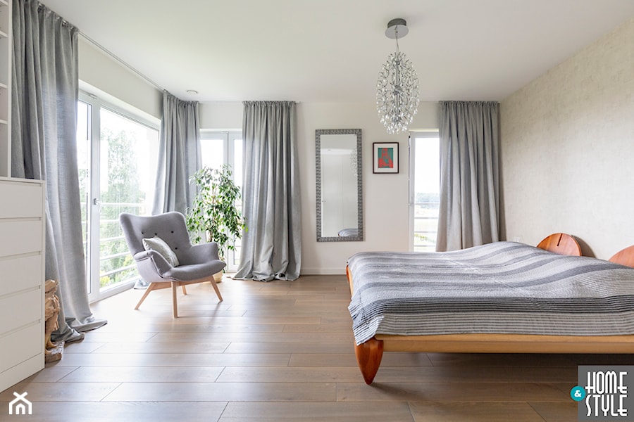Przestronna biała sypialnia z drewnianym łóżkiem - zdjęcie od HOME & STYLE Katarzyna Rohde