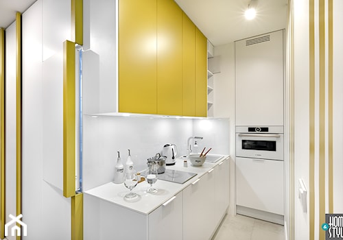REALIZACJA apartamentu hotelowego - Mała z żółtymi frontami otwarta z salonem biała z zabudowaną lodówką z podblatowym zlewozmywakiem kuchnia w kształcie litery l, styl nowoczesny - zdjęcie od HOME & STYLE Katarzyna Rohde