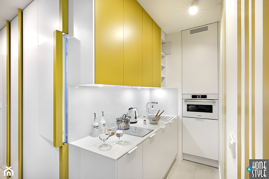 REALIZACJA apartamentu hotelowego - Mała z żółtymi frontami otwarta z salonem biała z zabudowaną lodówką z podblatowym zlewozmywakiem kuchnia w kształcie litery l, styl nowoczesny - zdjęcie od HOME & STYLE Katarzyna Rohde