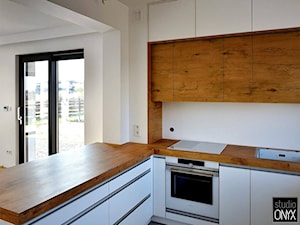 Kuchnie nowoczesne - Średnia z salonem biała z zabudowaną lodówką kuchnia w kształcie litery l z wyspą lub półwyspem, styl nowoczesny - zdjęcie od STUDIO ONYX