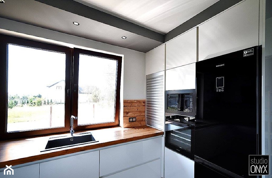 Kuchnie nowoczesne - Średnia biała z zabudowaną lodówką z nablatowym zlewozmywakiem kuchnia jednorzędowa z oknem, styl nowoczesny - zdjęcie od STUDIO ONYX