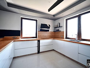 Kuchnie nowoczesne - Średnia zamknięta biała z zabudowaną lodówką z nablatowym zlewozmywakiem kuchnia w kształcie litery u z oknem, styl nowoczesny - zdjęcie od STUDIO ONYX