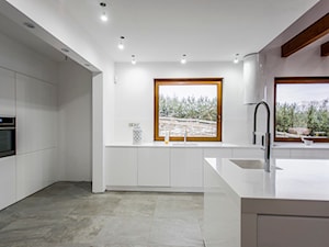 Dom nad jeziorem - Duża otwarta z kamiennym blatem biała z zabudowaną lodówką z podblatowym zlewozmywakiem kuchnia w kształcie litery g z wyspą lub półwyspem, styl nowoczesny - zdjęcie od SELFIA