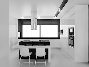 Czarno na białym - Duża otwarta biała czarna z zabudowaną lodówką z podblatowym zlewozmywakiem kuchnia w kształcie litery l z wyspą lub półwyspem, styl minimalistyczny - zdjęcie od Manufaktura Studio grupa projektowa