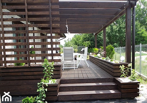 Zabudowa tarasu - Średni z podłogą z desek z meblami ogrodowymi z donicami na kwiaty taras z tyłu domu - zdjęcie od Bryniak Woodworking