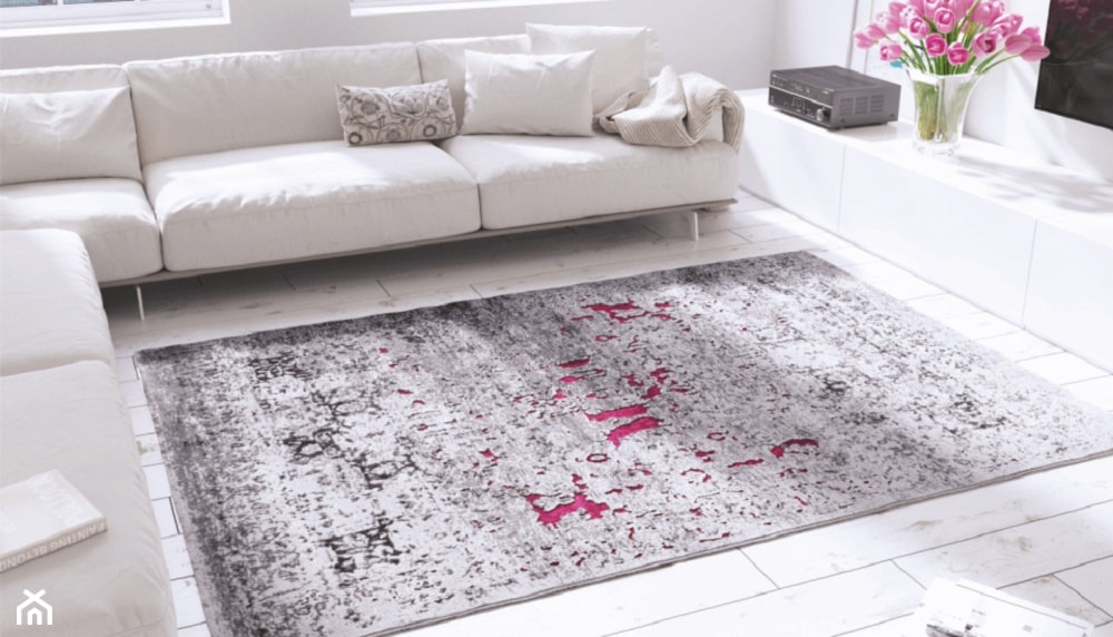 biały narożnik do salonu, dywan stylizowany na stary, białe deski na podłodze