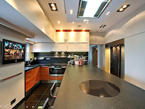TV - Średnia otwarta biała czarna z zabudowaną lodówką z podblatowym zlewozmywakiem kuchnia w kształcie litery u z wyspą lub półwyspem z kompozytem na ścianie nad blatem kuchennym, styl nowoczesny - zdjęcie od Loewe