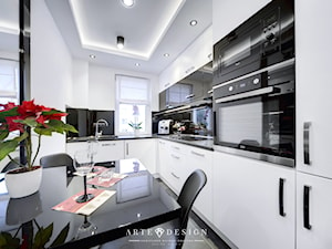 Apartament w Gdyni - Średnia zamknięta biała czarna z zabudowaną lodówką z podblatowym zlewozmywakiem kuchnia w kształcie litery l z wyspą lub półwyspem, styl nowoczesny - zdjęcie od Arte Dizain