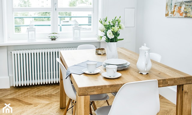drewniany stół, drewniana podłoga, biały kaloryfer pod oknem