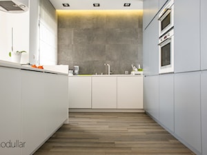 Dom w Wawrze - Duża otwarta zamknięta szara z zabudowaną lodówką kuchnia w kształcie litery u, styl minimalistyczny - zdjęcie od MODULLAR