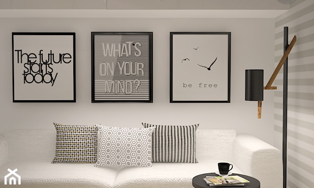 biała sofa, czarny stolik, czarno-białe grafiki dekoracyjne, poduszka w paski, poduszka w kropki, ściana w szare pasy