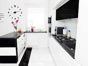 Mieszkanie w Siedlcach - Białe Meble kuchenne z czarnym - Średnia otwarta z salonem z kamiennym blatem biała z zabudowaną lodówką z podblatowym zlewozmywakiem kuchnia w kształcie litery u z wyspą lub półwyspem, styl nowoczesny - zdjęcie od Meble na wymiar Kulenty