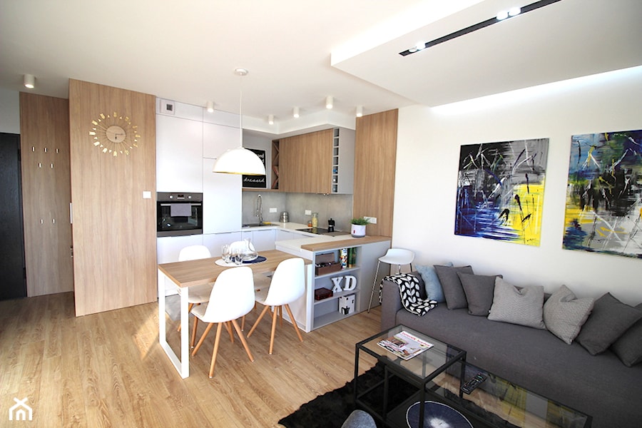 Nowoczesne mieszkanie w apartamentowcu, biel i szarość ocieplane drewnem - Średnia otwarta z salonem ... - zdjęcie od MK HOME