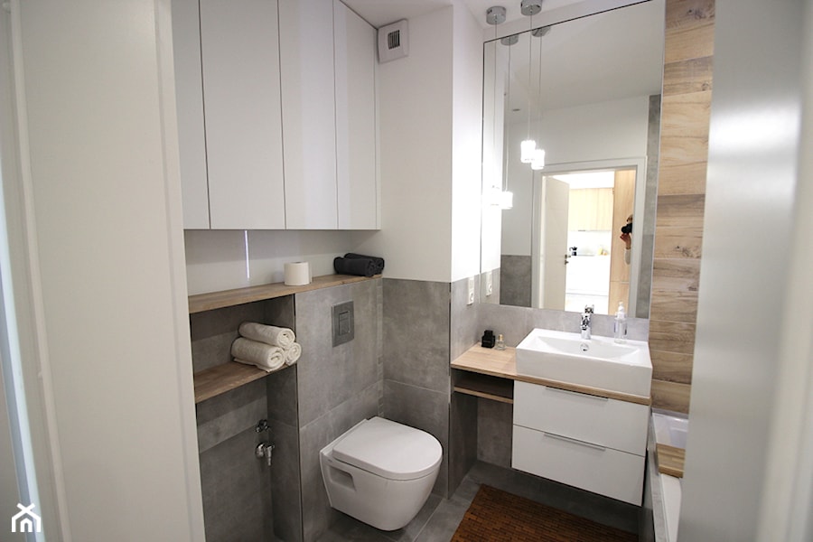 Nowoczesne mieszkanie w apartamentowcu, biel i szarość ocieplane drewnem - Mała bez okna z lustrem łazienka, styl nowoczesny - zdjęcie od MK HOME