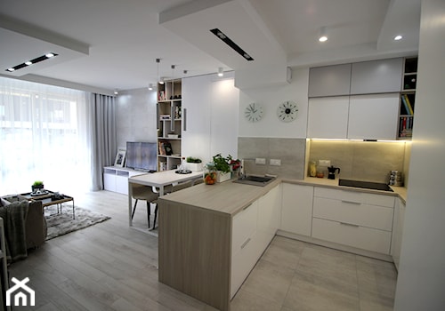 Eleganckie, nowoczesne, jasne mieszkanie w apartamentowcu - Średnia otwarta z salonem biała z zabudowaną lodówką z nablatowym zlewozmywakiem kuchnia w kształcie litery u z marmurem nad blatem kuchennym, styl nowoczesny - zdjęcie od MK HOME
