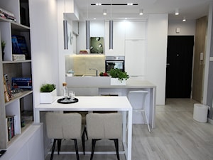 Eleganckie, nowoczesne, jasne mieszkanie w apartamentowcu - Mała z salonem biała z zabudowaną lodówką z podblatowym zlewozmywakiem kuchnia w kształcie litery u z wyspą lub półwyspem, styl nowoczesny - zdjęcie od MK HOME