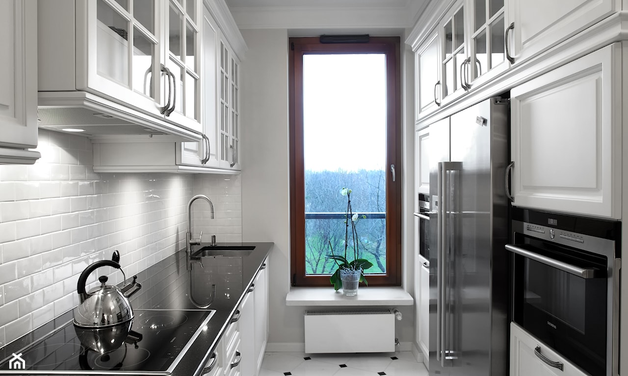 wąska kuchnia, białe szafki z czarnym blatem, duże okno